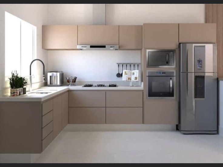 a modern kitchen with beige cabinets and stainless steel appliances, including a refrigerator freezer