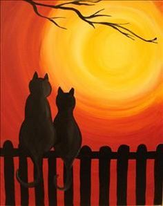 two cats sitting on a fence watching the sunset