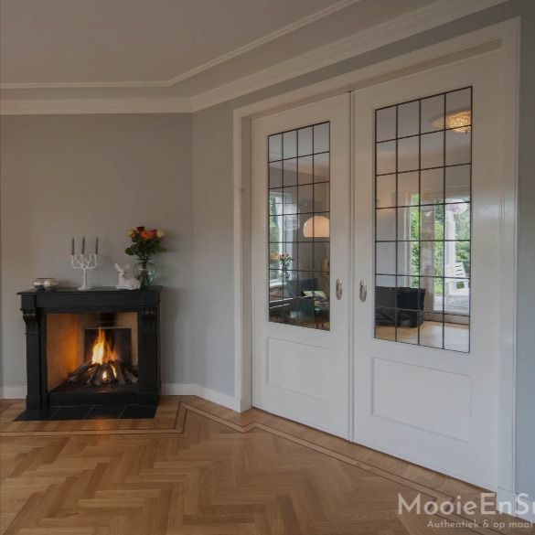 a living room with a fire place in the center and two doors leading to another room