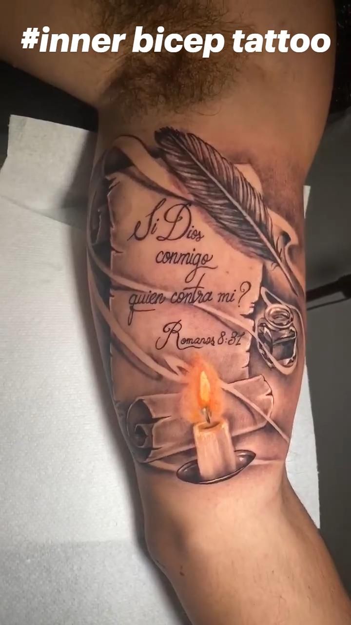 a man's arm with a candle and some writing on it