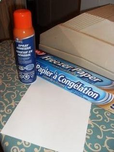 there are two tubes of glue next to a piece of paper and a box of toilet paper