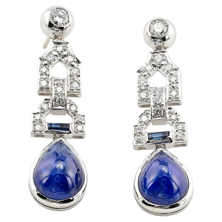 These superbly designed late Art Deco Diamond and Sapphire earrings are 1935/40 circa Exquisitely hand crafted during the period of solid 14 Kt white gold, marked The earrings prize a chic geometric design of eternal style set with natural earth mined gemstones between bright white Diamonds and natural unheated Sapphires creating charming and effect altogether The fantastic Blue suspending drops are two natural untreated/ unheated natural Sapphires of intense rich Blue color assessed by our specialist - approx 14.00 Ct for both deep and beautiful cabochon drop shaped measuring 12.5 x 9.8 mm The articulated top line  is set with 1.00 Ct of Diamonds rated G VVS/VS further enhanced by two small baguette Sapphire of .15 Ct adding lovely contrast contrast Fine condition commensurate to age and Art Deco Sapphire Jewelry Gift, Art Deco Sapphire Jewelry Gia Certified, Blue Diamond-accented Evening Earrings, Art Deco Multi-stone Sapphire Jewelry, Elegant Blue Diamond-cut Earrings, Late Art, Diamond Drop Earrings, Art Deco Earrings, Diamond Drops