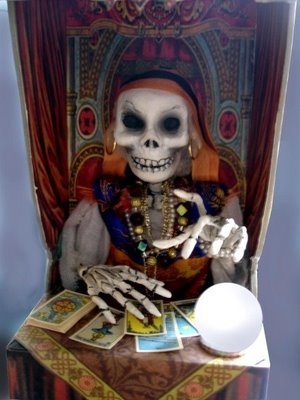 a skeleton sitting on top of a chair next to cards and a white light bulb