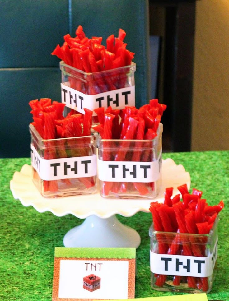 there are red chili peppers in small plastic containers on the table with name tags and place cards