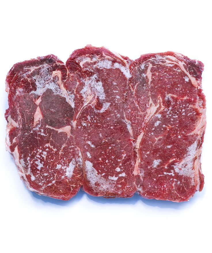 three pieces of raw meat sitting on top of each other in front of a white background