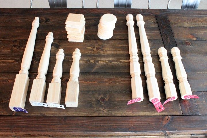 some white wooden railings and posts on a wood table with pink tape around them