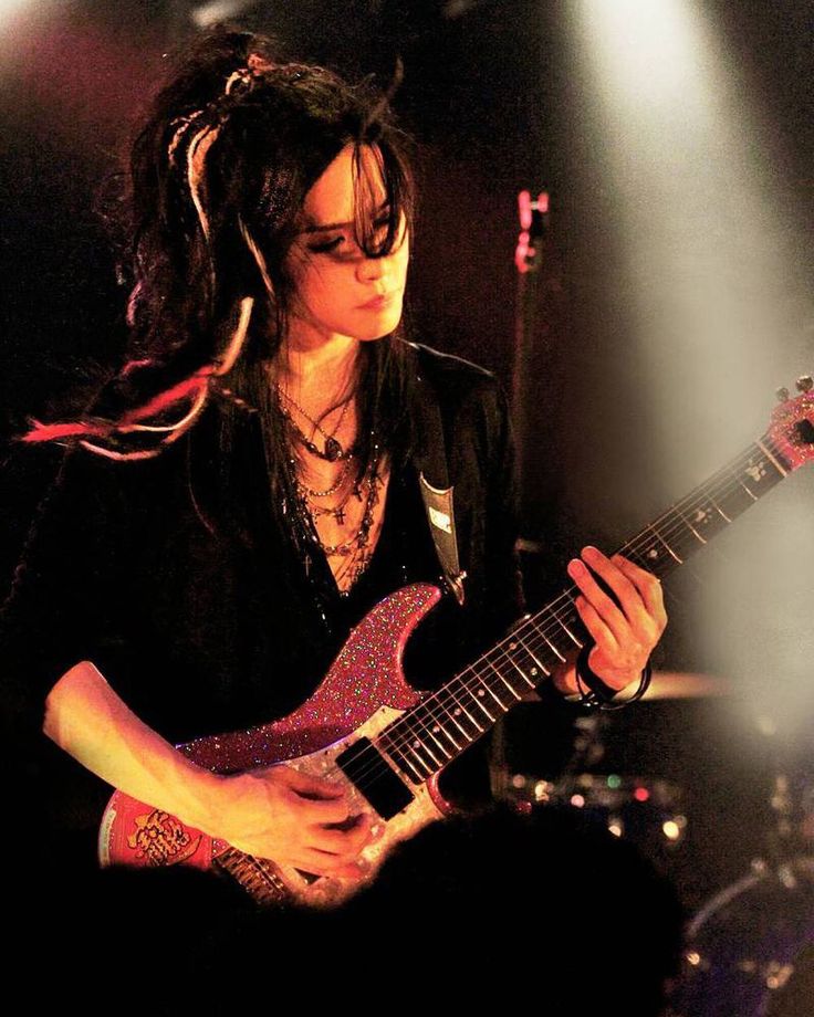 a woman playing an electric guitar on stage