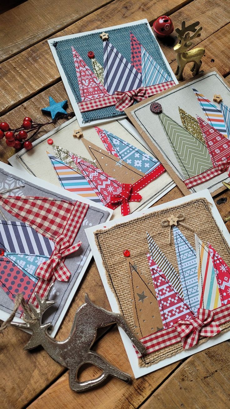 four cards with different designs on them sitting on a wooden table next to scissors and other items