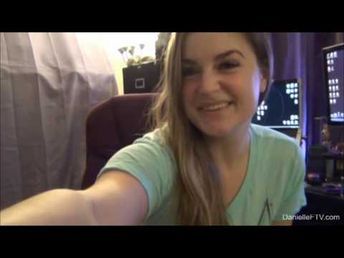 a girl with long hair is smiling and posing for the camera in front of her computer desk