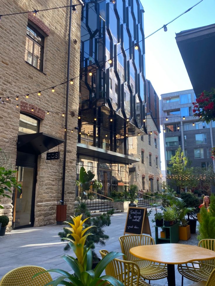 an outdoor cafe with tables and yellow chairs