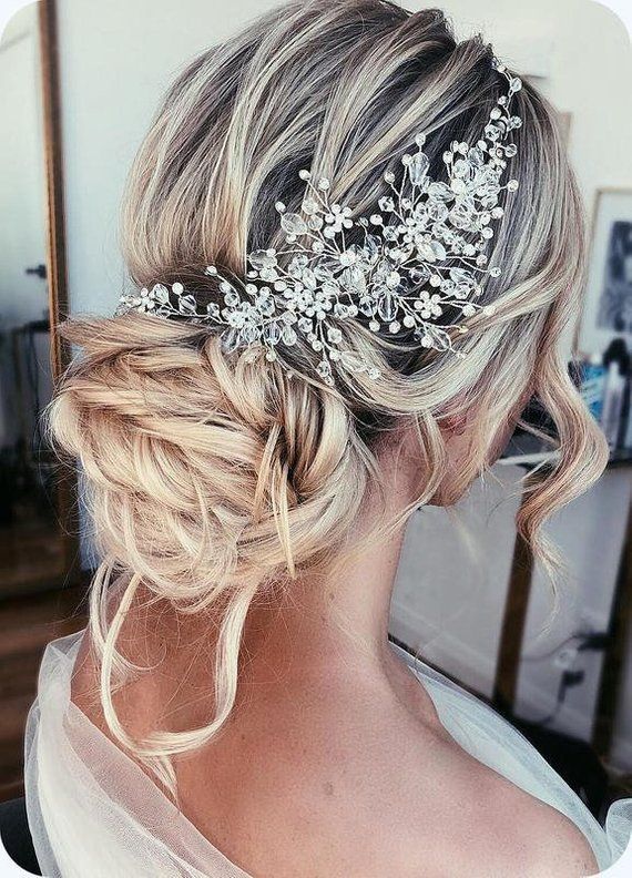 a woman with blonde hair wearing a bridal headpiece in front of a mirror