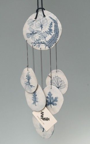 a wind chime with five blue and white plates hanging from it's hooks