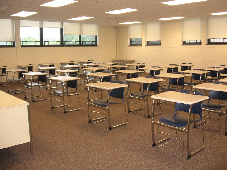 an empty classroom with desks and chairs