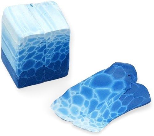 two pieces of blue and white soap sitting next to each other on a white surface