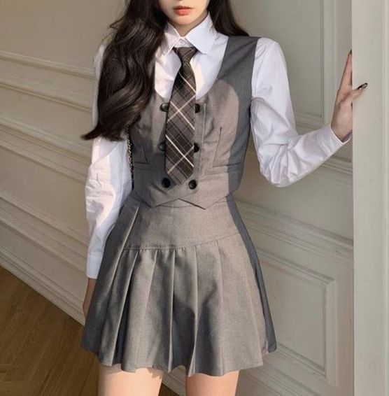 a young woman dressed in a school uniform posing for the camera with her hands on her hips