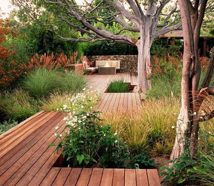 a wooden deck surrounded by plants and trees