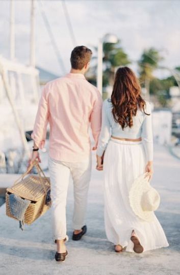 a man and woman walking down the street holding hands