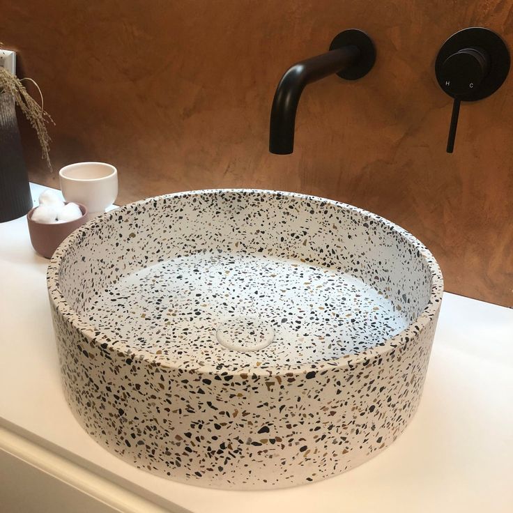 a black and white sink sitting on top of a counter next to a faucet