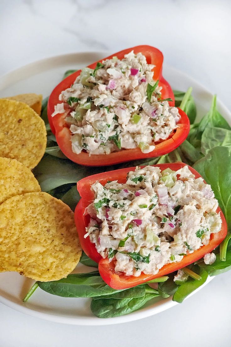 two red peppers with chicken salad on them and tortilla chips