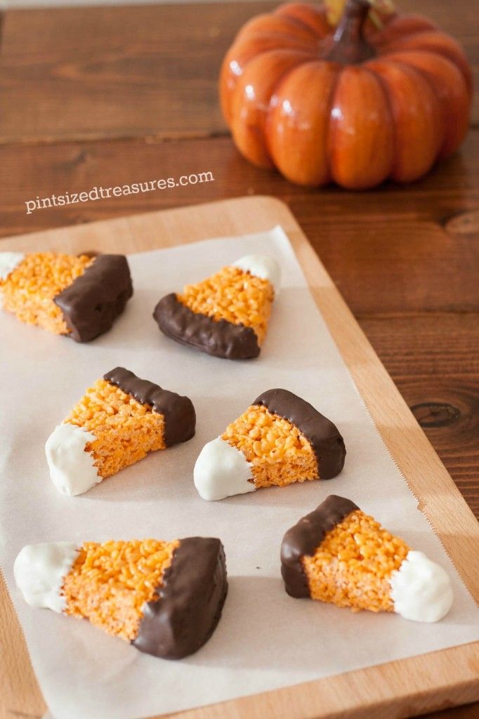 several pieces of cake sitting on top of a wooden cutting board next to a pumpkin