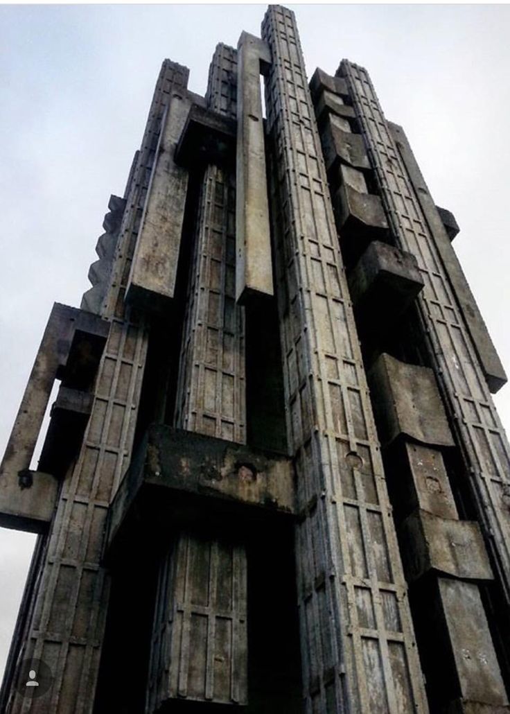 a very tall building with lots of windows on it's sides and wooden slats at the top