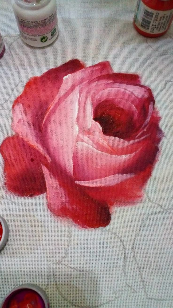 a rose painted on a table with some paint