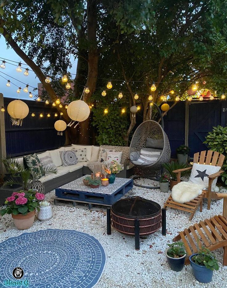 an outdoor living area with hanging lights and furniture