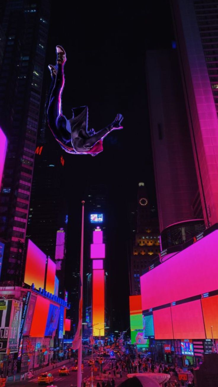 the city is lit up at night with neon lights and tall buildings in the background