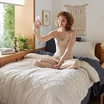 a woman sitting on her bed taking a selfie