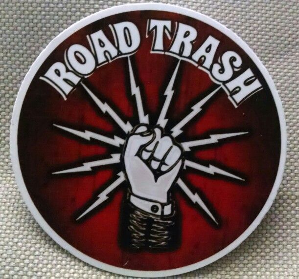 a red and white sign with the word road trash on it's side, in front of a background of other stickers