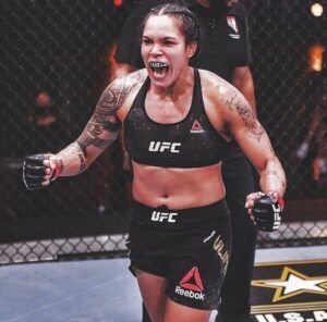 a female fighter with her mouth open and fists out