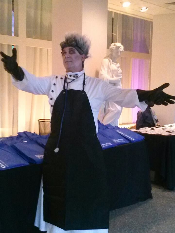 a man dressed as a chef standing in front of blue bins with arms outstretched