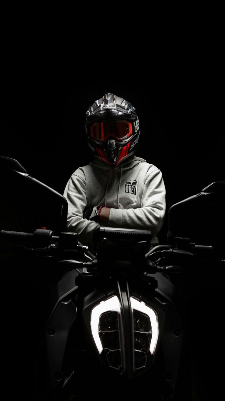 a man sitting on top of a motorcycle in the dark