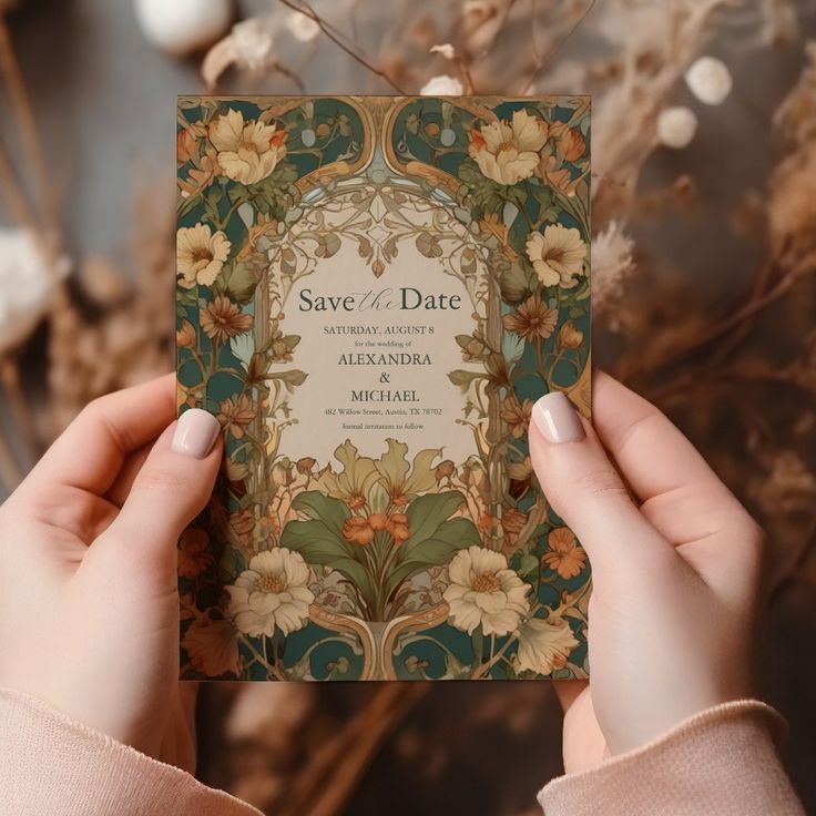 a person holding up a wedding card in front of some dried flowers and branches with the words save - date printed on it