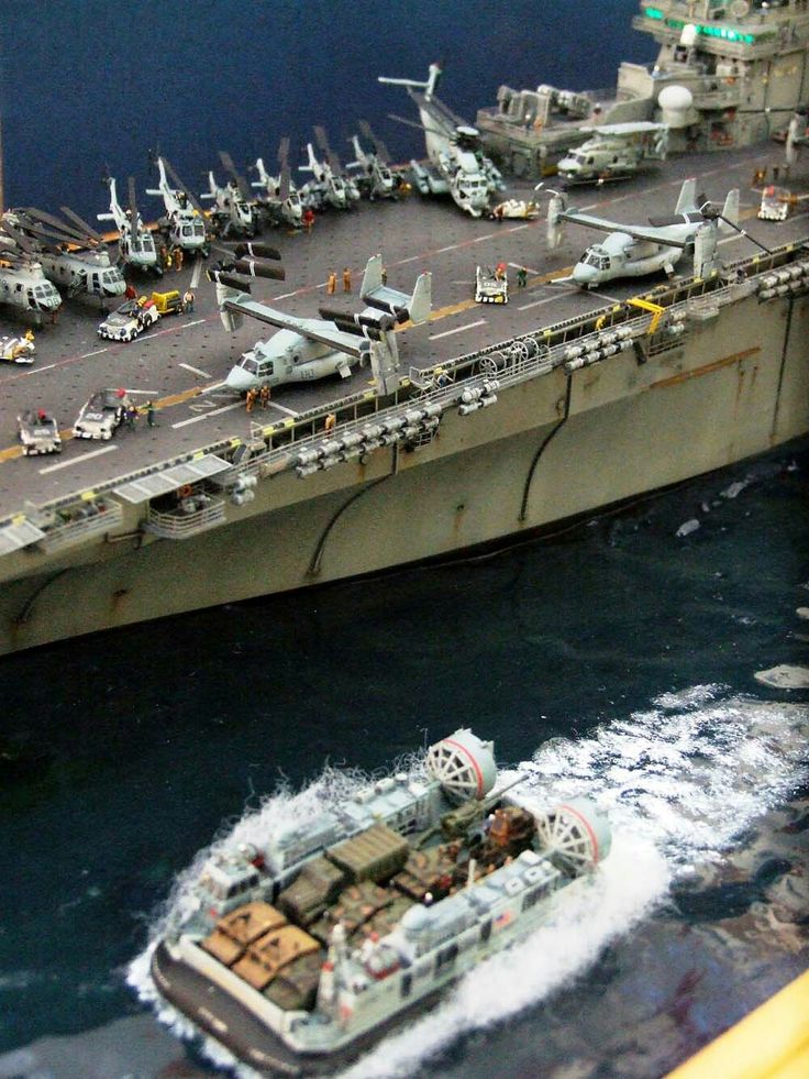 an aircraft carrier is in the water next to another ship