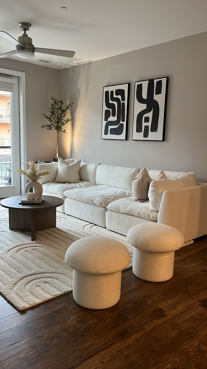 a living room filled with white furniture and a large open door to the outside patio