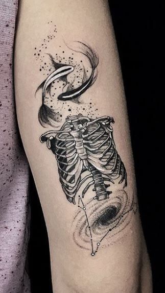 a tattoo on the arm of a person with a black and white image of a skeleton