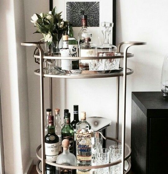 a bar cart filled with liquor bottles and glasses