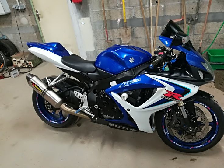 a blue and white motorcycle parked in a garage