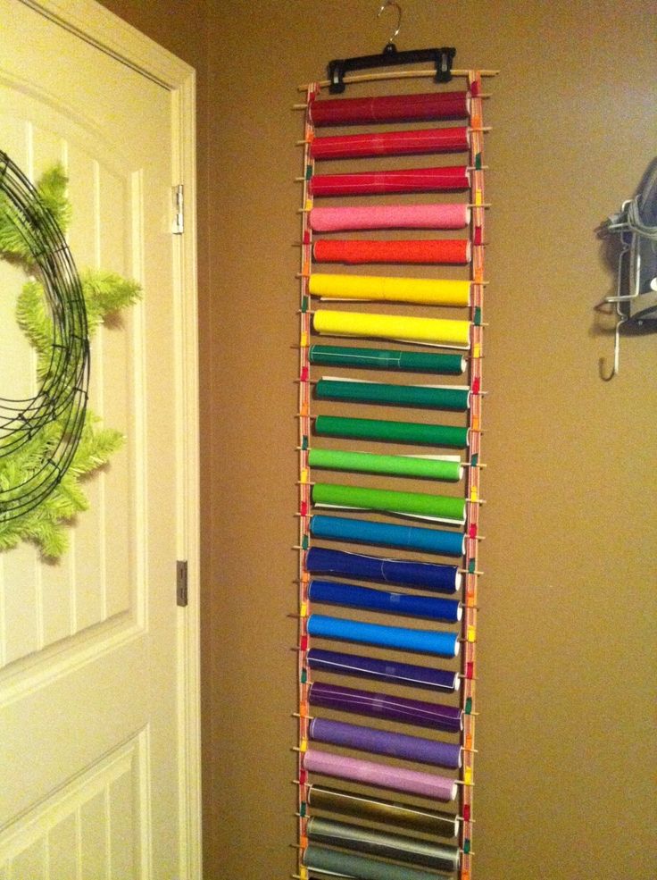 a rack with many different colored ribbons hanging from it's sides next to a door