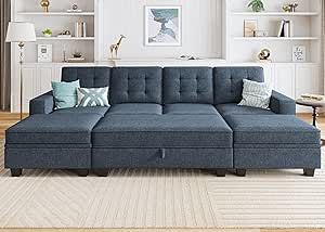 a living room with a blue couch and bookshelves on the wall behind it