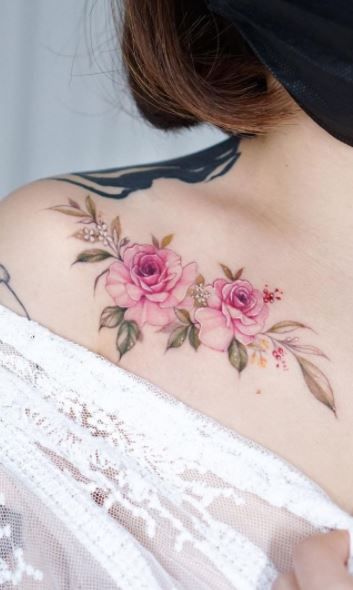 a woman's back shoulder with pink roses on it