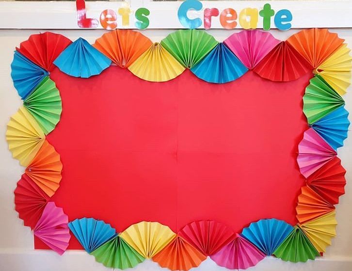 colorful paper umbrellas are arranged in the shape of a heart on a bulletin board