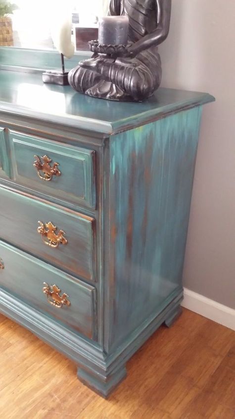 a blue dresser with a buddha statue on top