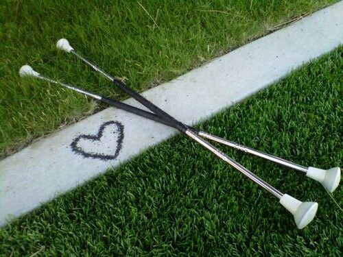 two golf tees laying on the grass with a heart drawn on it's side