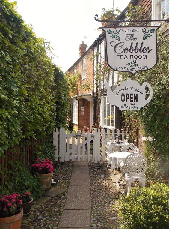 the cobblestone path leads to an outdoor cafe and tea room in this small town