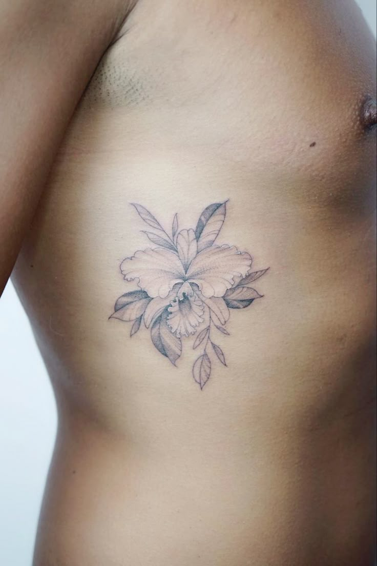 a close up of a person's stomach with a flower tattoo on the side