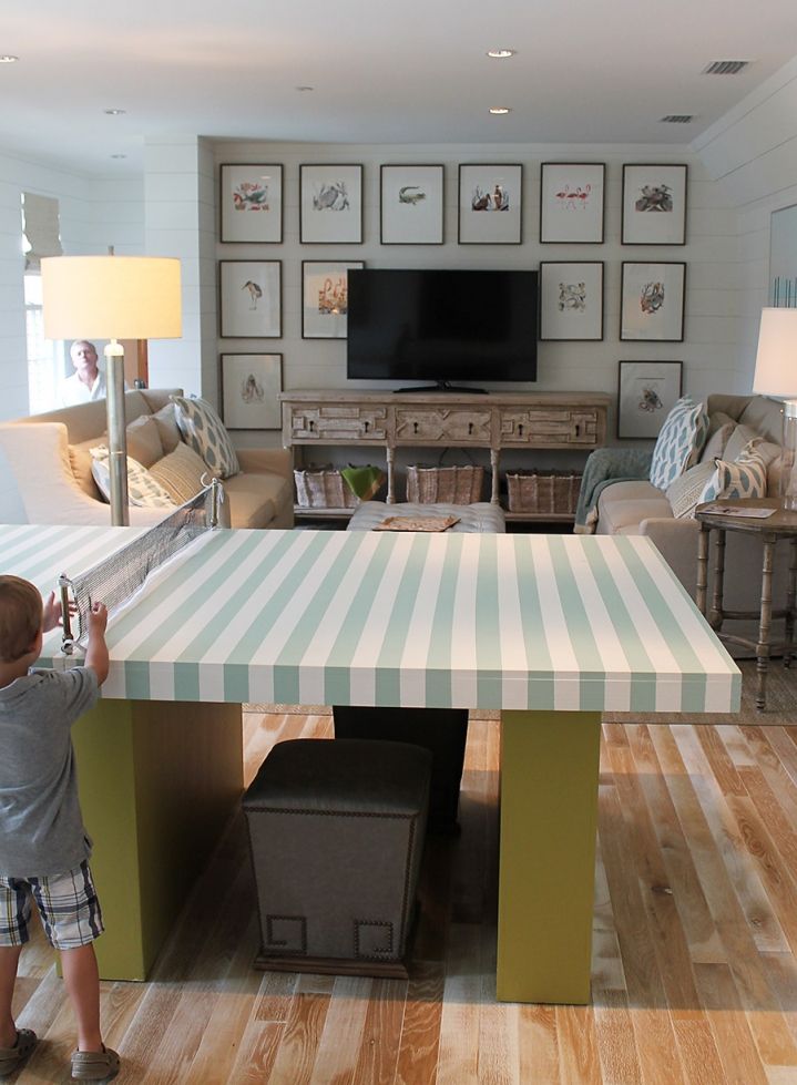 a little boy standing in front of a table with a tv on top of it