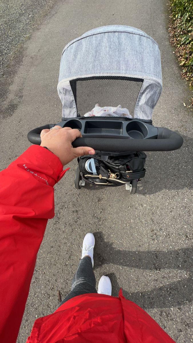 the person is holding onto their stroller on the road