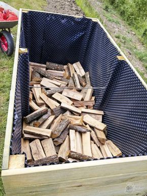 a large crate filled with wood sitting in the grass